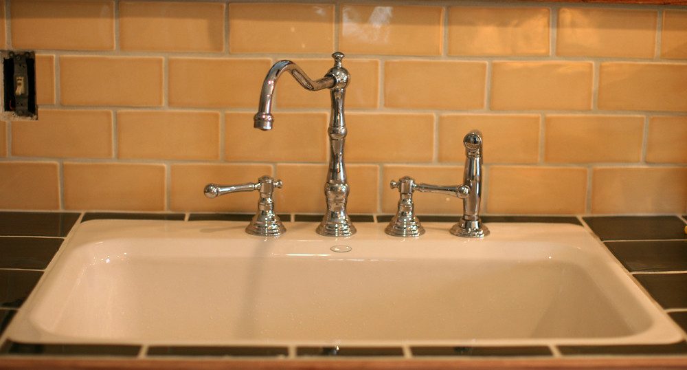 Bridge kitchen faucet with two handles joined to the spout by an exposed crosspipe