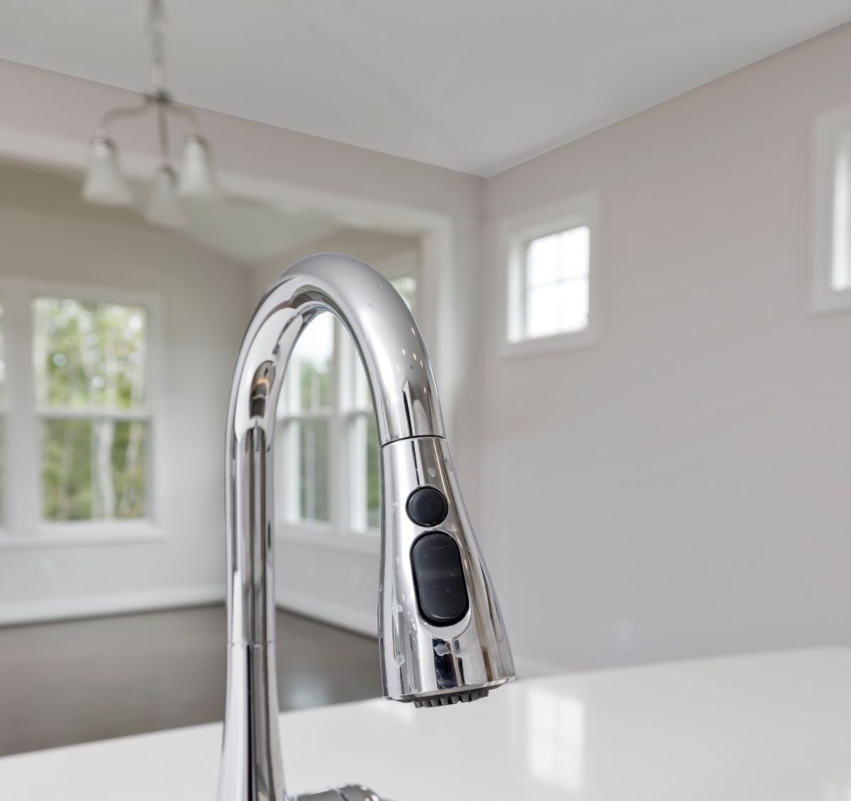 Pull-down kitchen faucet with a high-arc gooseneck spout and spray head that pulls down into the sink