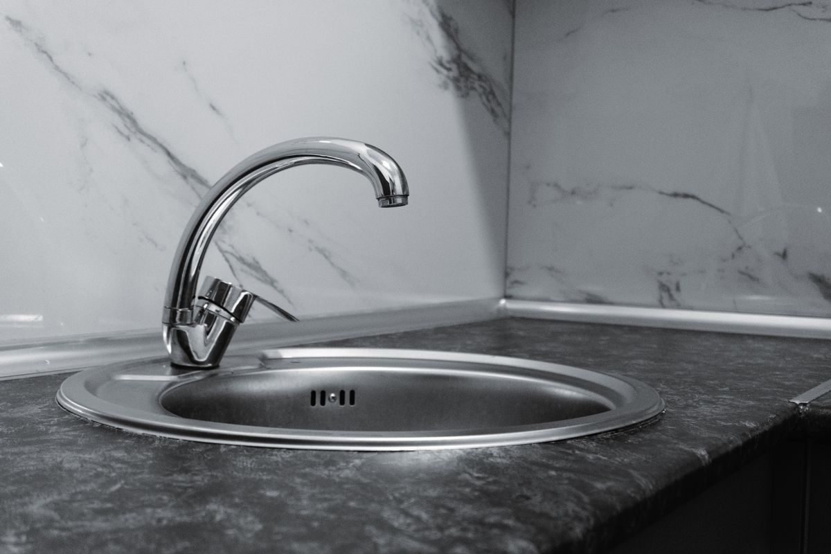 Single-handle kitchen faucet with a curved spout controlled by one lever