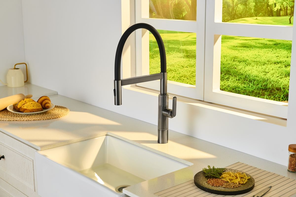 Pull-down kitchen faucet with a tall gooseneck spout over a farmhouse sink